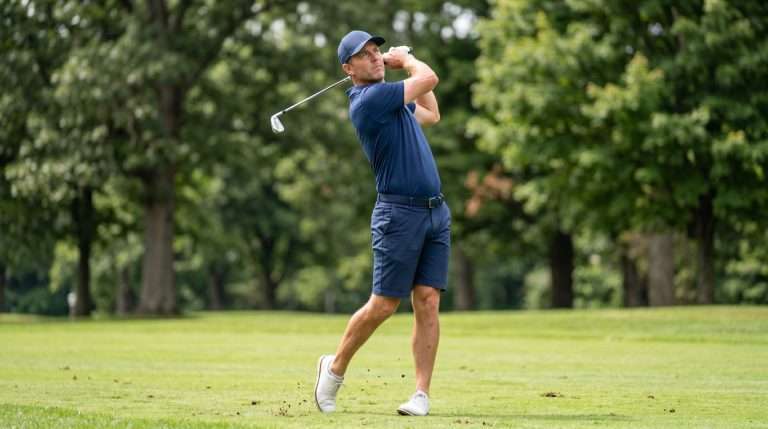 Golfer finishing a full golf swing on a fairway near Holland, Michigan